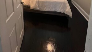 A bedroom with a bed, a ceiling fan, a window, and a TV on a stand. - The Isabella - Beautifully Revived Historic House - 2 blocks from the IP Mill (Bogalusa)