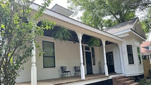 A single-story house with a covered porch, a front door, and a small front yard. - The Isabella - Beautifully Revived Historic House - 2 blocks from the IP Mill (Bogalusa)
