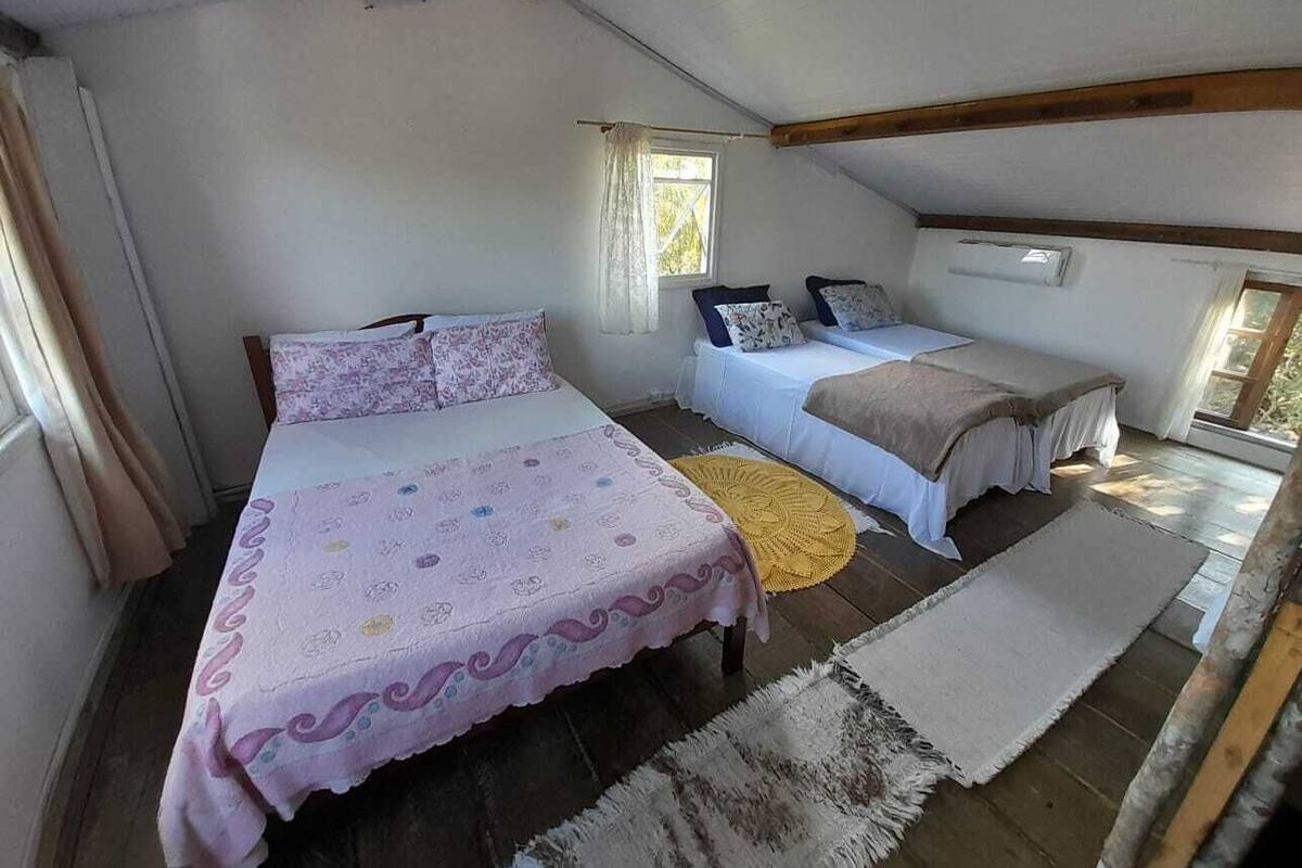 Une chambre avec deux lits, une fenêtre et un appareil de climatisation.