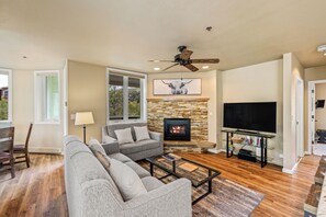 Ein Wohnzimmer mit Kamin, Fernseher und Deckenventilator.