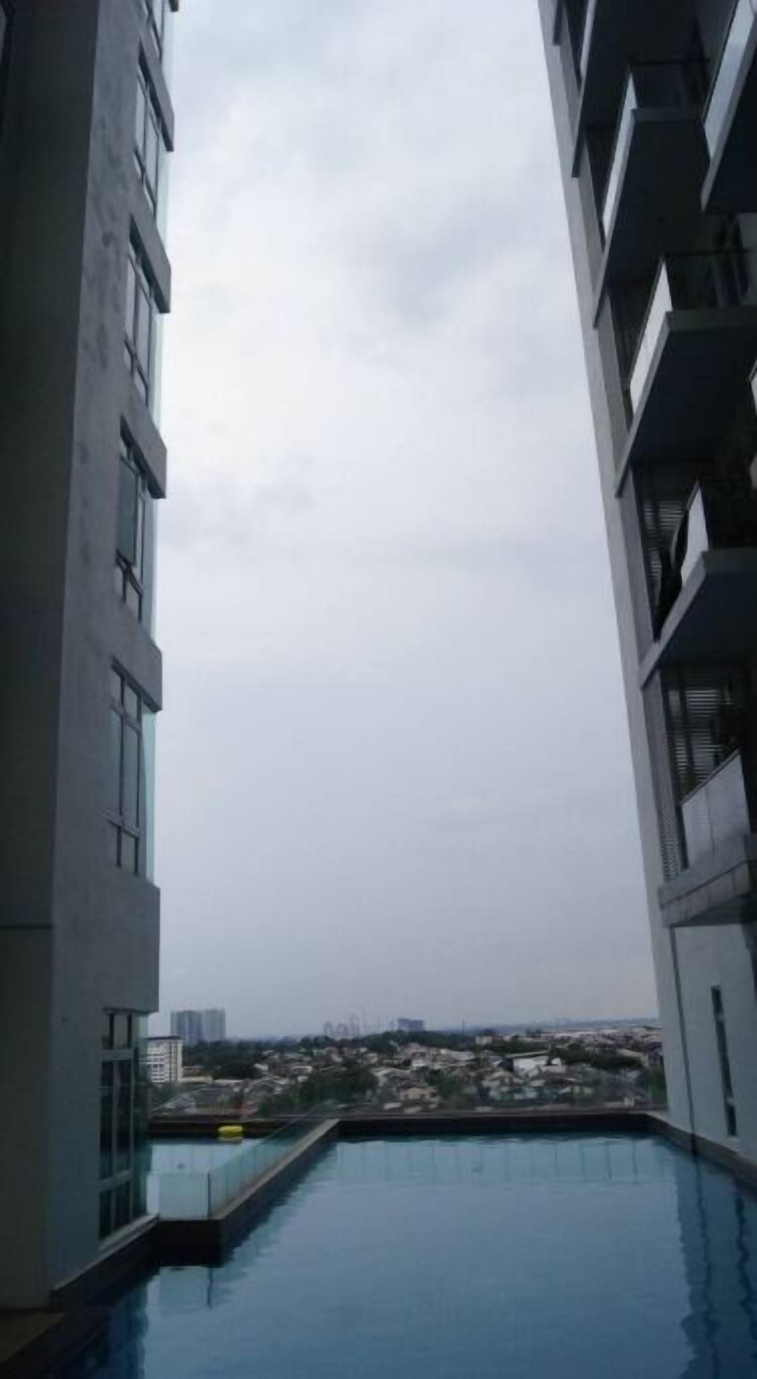 A modern building with a rooftop pool and a view of a cityscape.