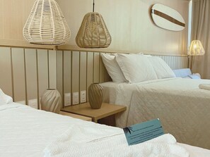A hotel room with two beds, a bedside table, a vase, and a wall-mounted light fixture. - Setai Yacht - Garden III - By Almare (João Pessoa)