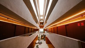 A modern hotel corridor with a central walkway, glass railings, and a ceiling with linear lighting. - Setai Yacht - Garden III - By Almare (João Pessoa)