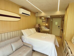 A hotel room with a bed, a sofa, a desk, and an air conditioning unit. - Setai Yacht - Garden III - By Almare (João Pessoa)