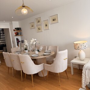 A dining area with a round table, six chairs, and a hanging light fixture. - Brand NEW penthouse with rooftop Terrace next to Disneyland Paris (Montévrain)