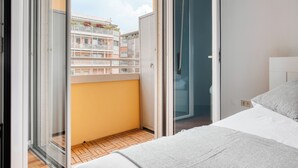 A bedroom with a bed, a sliding glass door leading to a balcony, and a view of a building. - Deltico; 4 guests in washington area (Milano)