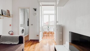 A modern living room with a sofa, a flat-screen TV, and a dining area with chairs and a table. - Deltico; 4 guests in washington area (Milano)