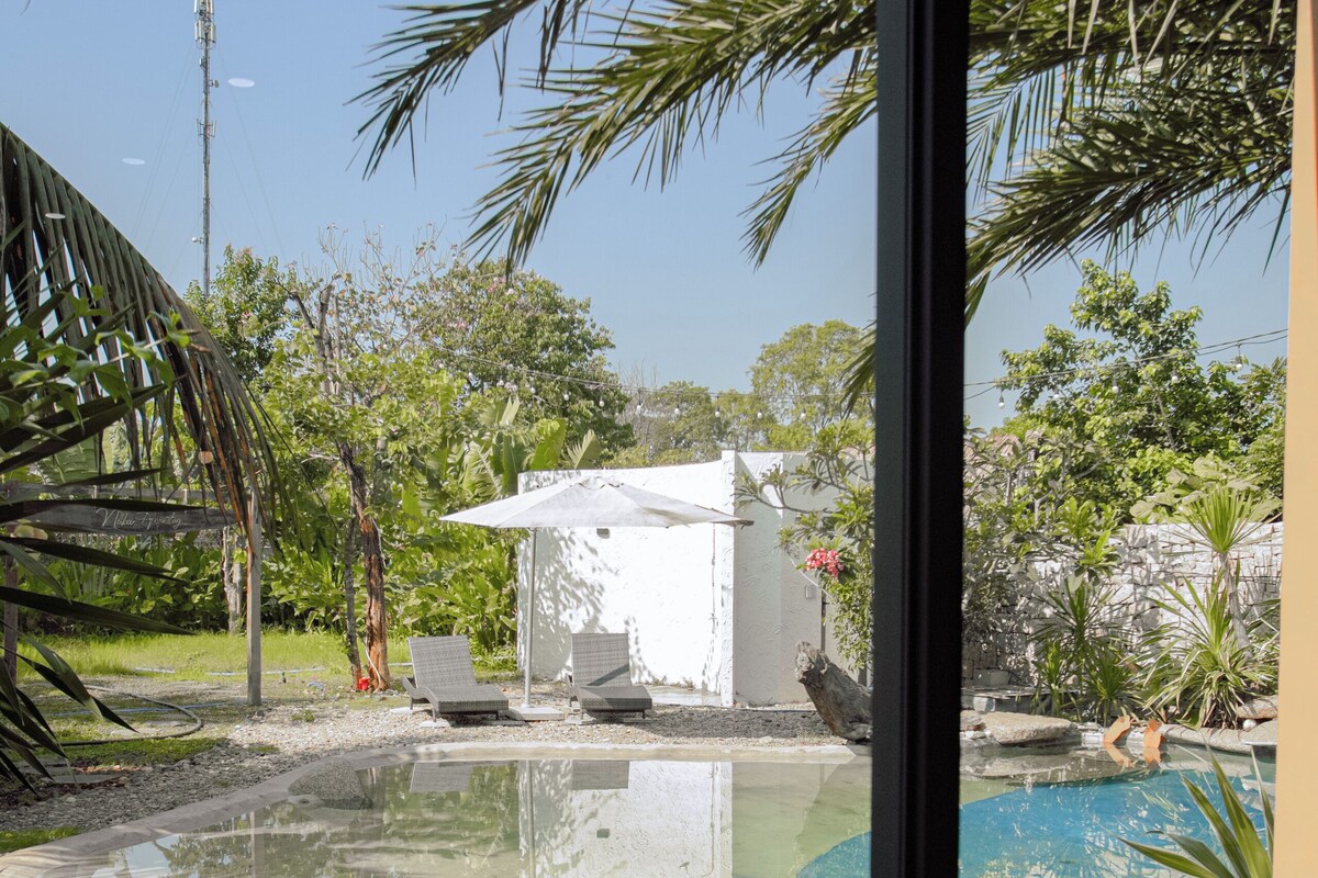 A pool area with lounge chairs, a small table, and a white structure.