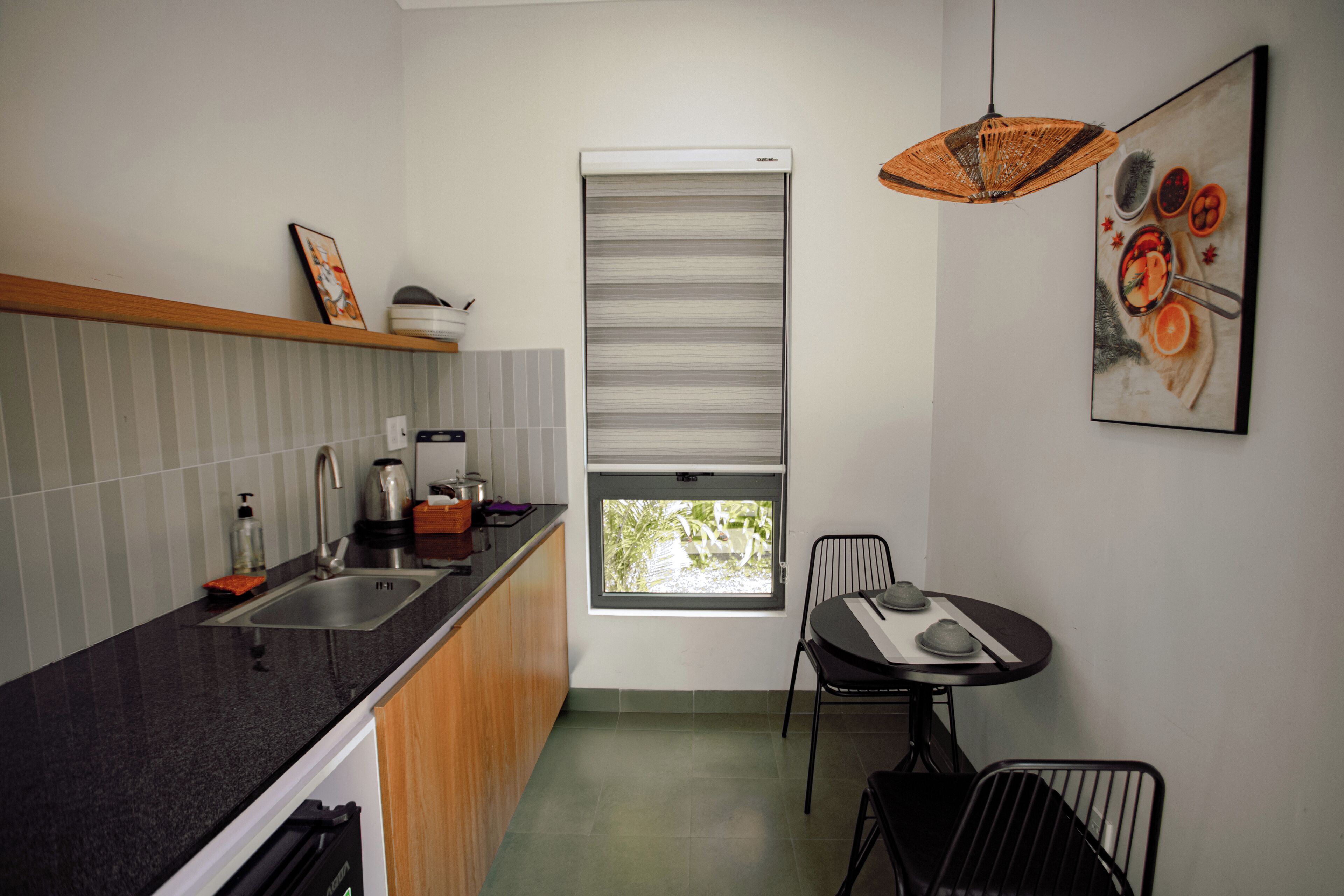 Una cocina moderna con lavamanos, estufa y comedor con sillas.