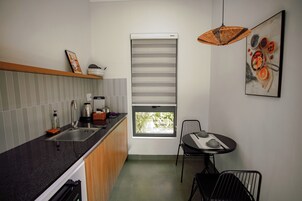 Una cocina moderna con lavamanos, estufa y comedor con sillas.