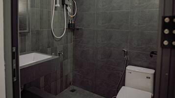 Een moderne badkamer met douche, toilet en wastafel.