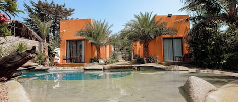 Una piscina al aire libre, sombrillas, sillones reclinables de piscina