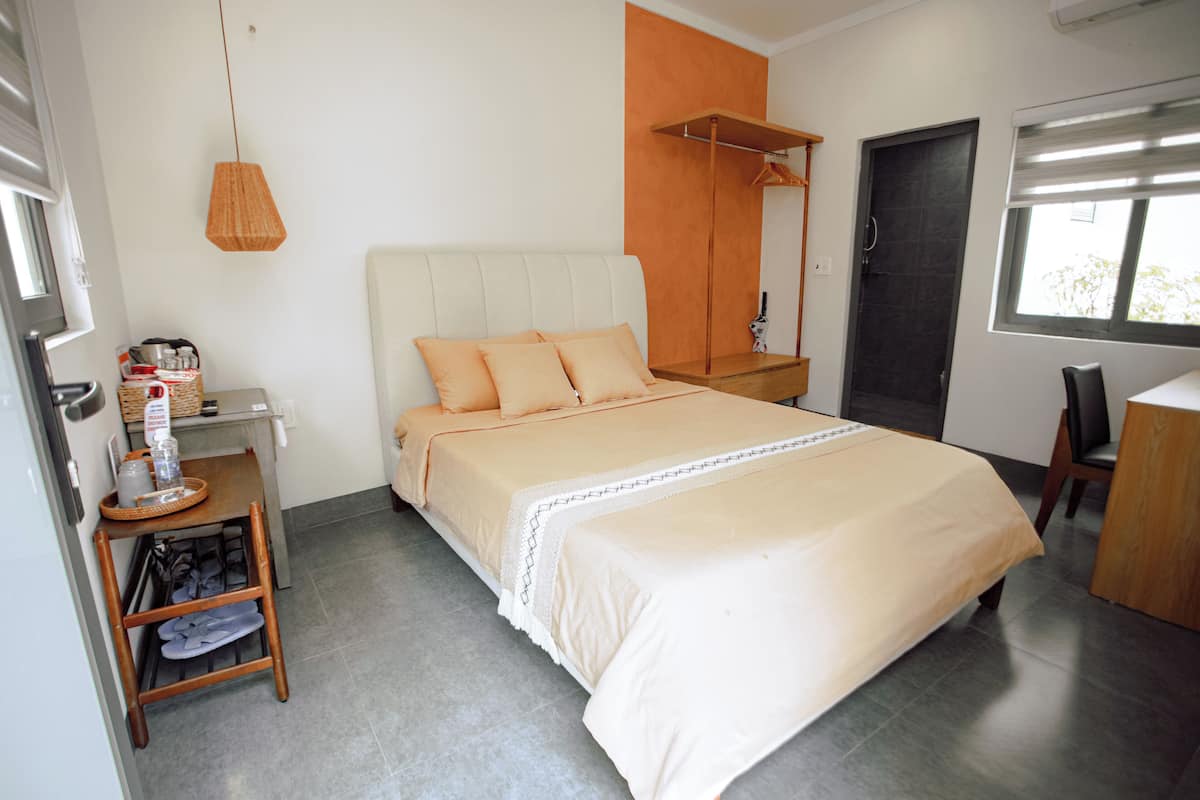 Une chambre à coucher moderne avec un lit, une table de chevet et une fenêtre.
