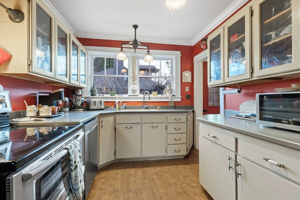 A kitchen with a stove, oven, sink, and cabinets. - Under the Eaves at Zion National Park (Springdale)