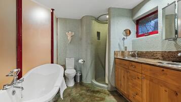 Un bagno con una vasca freestanding, un water e un box doccia.