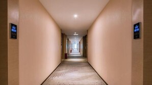 A long, narrow hotel corridor with beige walls and a patterned carpet. - Lavande Hotel(Dongguan Dongcheng Metro Station Wanda Plaza) (Dongguan)