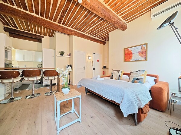 A modern room with a bed, a sofa, a small table, and a kitchen area. - Viva Riviera Croisette Carre d'Or (Cannes)