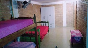 A room with two bunk beds, a wardrobe, and a small table. - El Bhuo Departamentos  (Villa Carlos Paz)