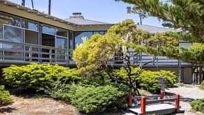 A modern building with large windows and a covered outdoor area.
