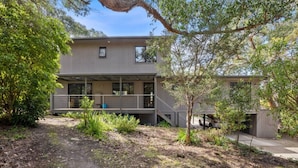 A modern two-story building with a balcony, surrounded by greenery. - Golf Edge (Anglesea)
