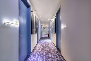 A hotel corridor with a patterned floor, doors labeled with room numbers, and overhead lighting. - Dingyi Hotel (Shanghai Ninth People's Hospital Lujia Bang Subway Station) (Shanghai)