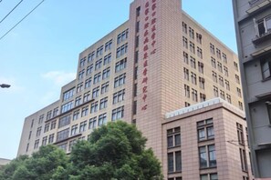 A multi-story building with a prominent corner section featuring large windows and a brick facade. - Dingyi Hotel (Shanghai Ninth People's Hospital Lujia Bang Subway Station) (Shanghai)