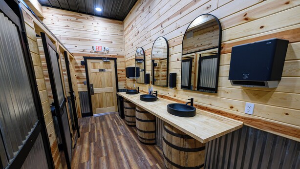 A wooden interior with a long counter, three sinks, and mirrors. - RV Site 8 Camper - Hatfield McCoy Trails (Wilkinson)