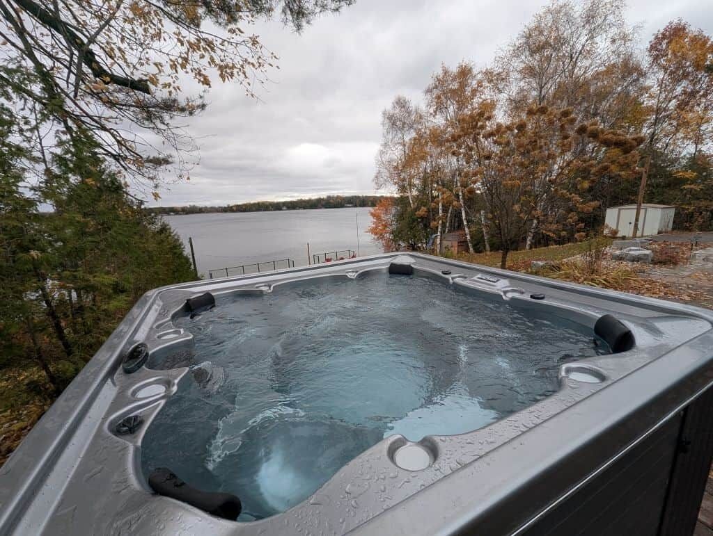 Ein Whirlpool mit Blick auf einen See und Bäume.