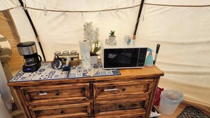 A kitchenette with a microwave, coffee maker, and various kitchen items on a wooden table. - Milky Way with AC and WiFi, glamping near Houston (Cleveland)