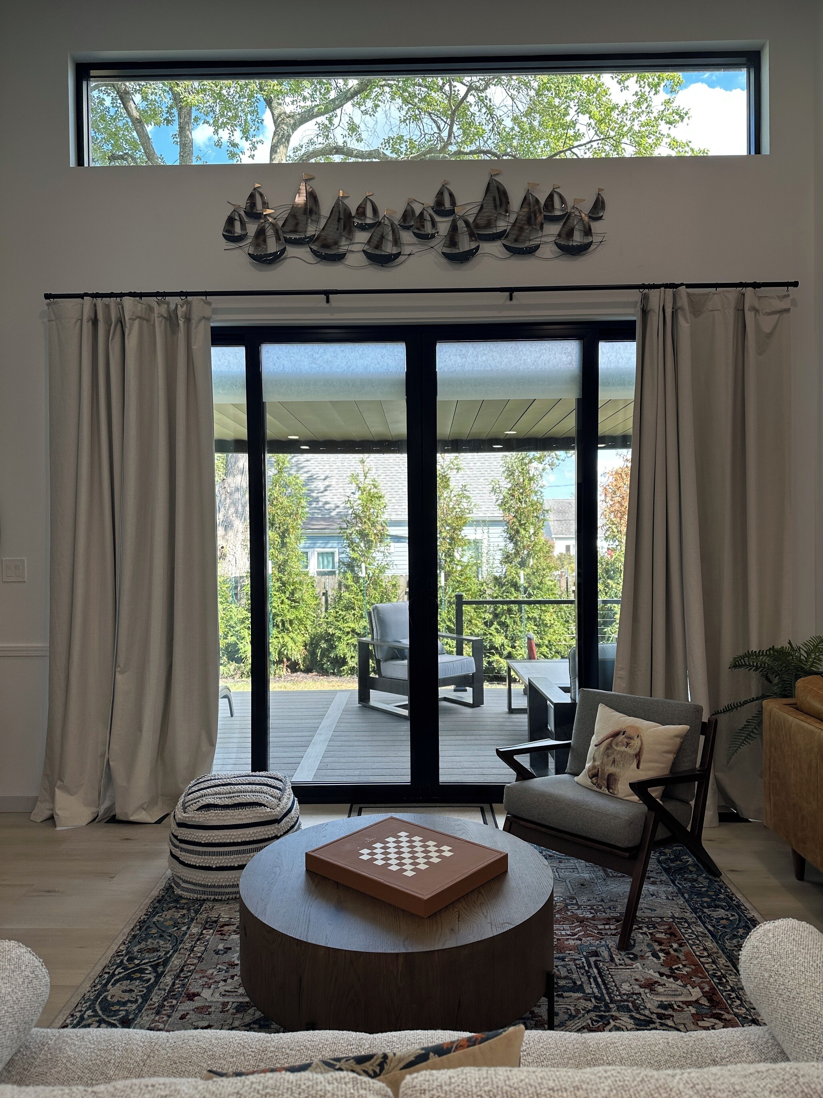A modern living room with a large sliding glass door leading to an outdoor patio.