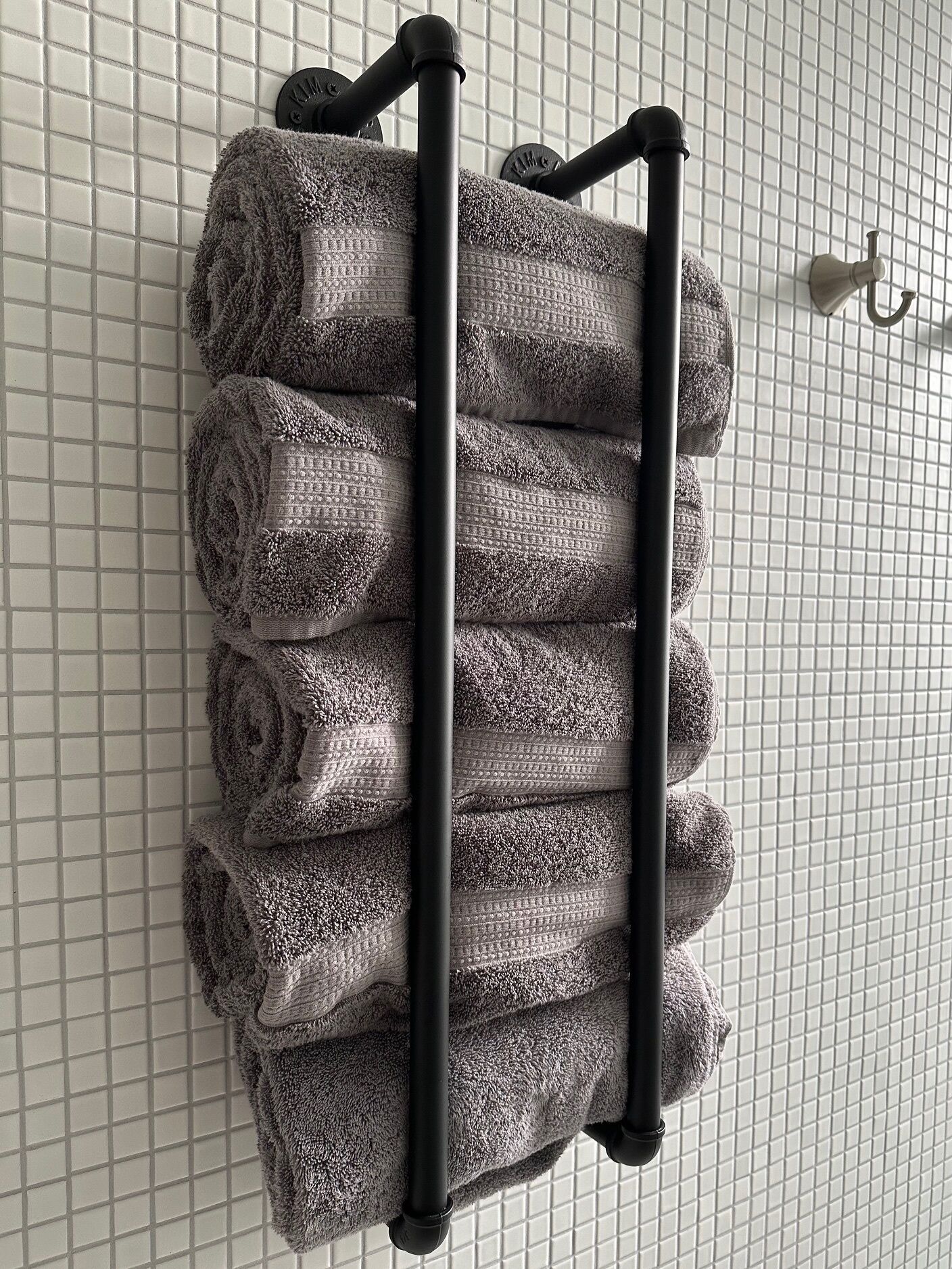 Ein Handtuchhalter mit mehreren ordentlich gefalteten Handtüchern.
