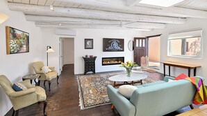 A living room with a fireplace, two armchairs, a sofa, and a coffee table.