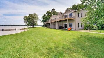 A two-story house with a covered porch and a view of a lake.