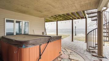 A hot tub under a pergola with a stone pathway leading to a staircase.