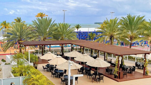 A rooftop bar with outdoor seating and a view of the ocean. - Solar Tambaú Luxo - By Almare Flats (João Pessoa)