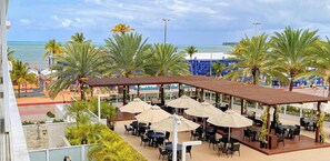 A rooftop bar with outdoor seating and a view of the ocean. - Solar Tambaú Luxo - By Almare Flats (João Pessoa)