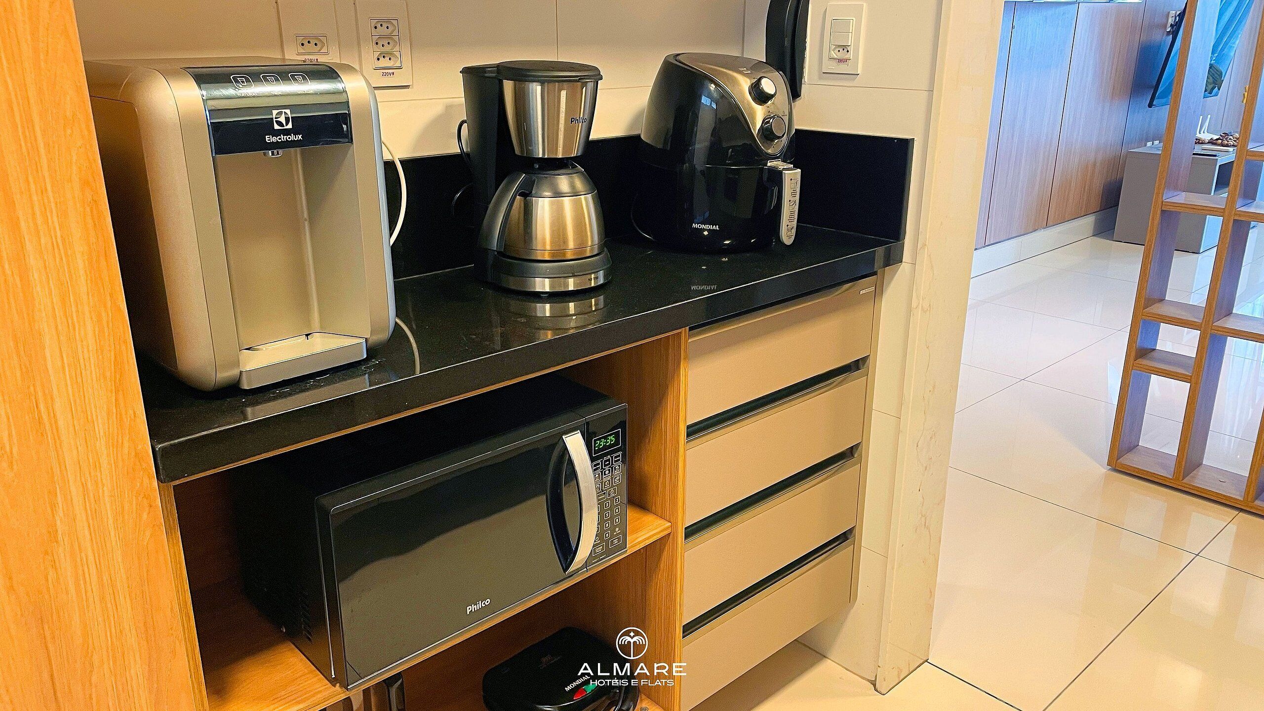 Una kitchenette con tostapane, macchina del caffè e forno a microonde.