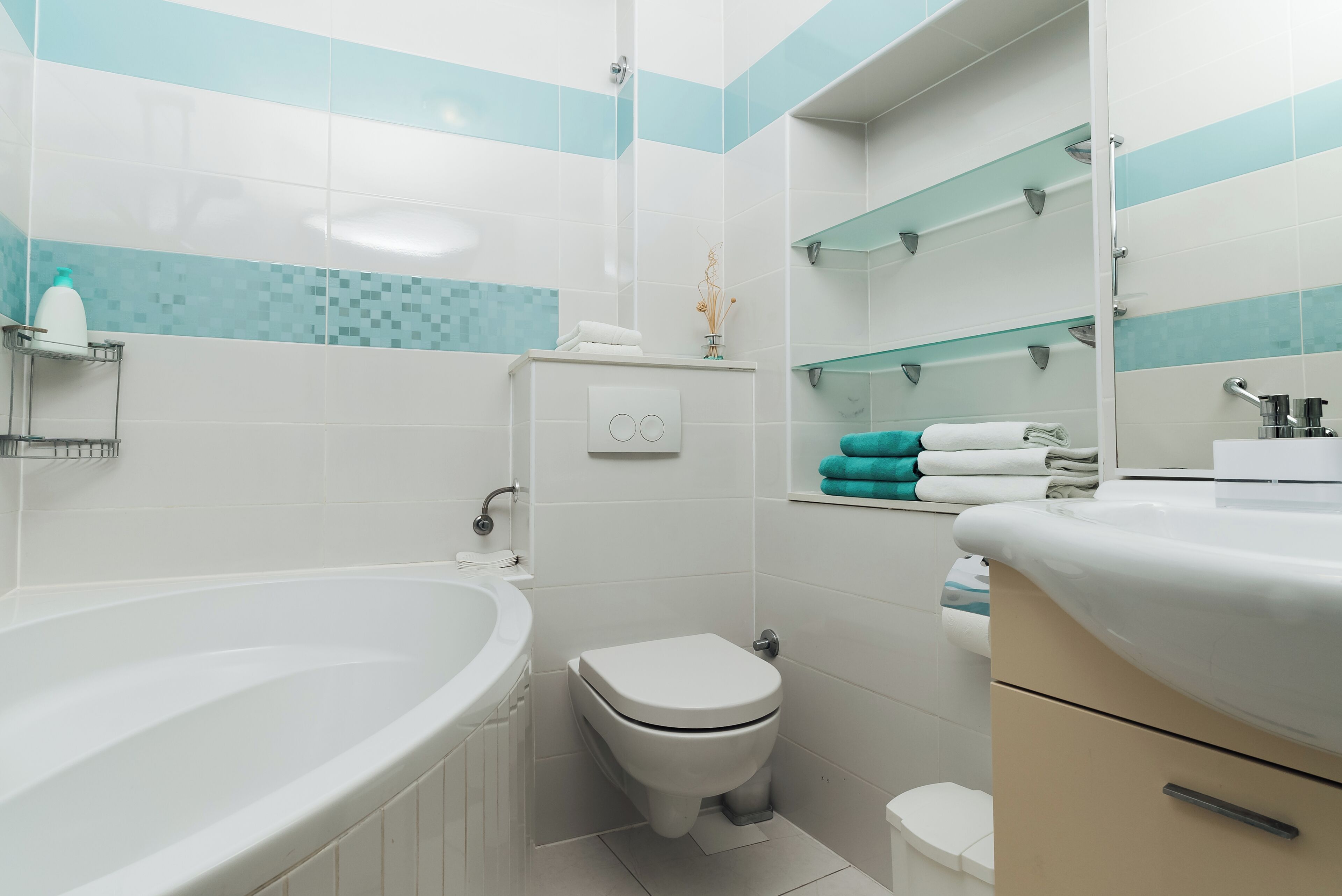 Une salle de bain moderne équipée d’une baignoire, de toilettes et d’un meuble-lavabo.