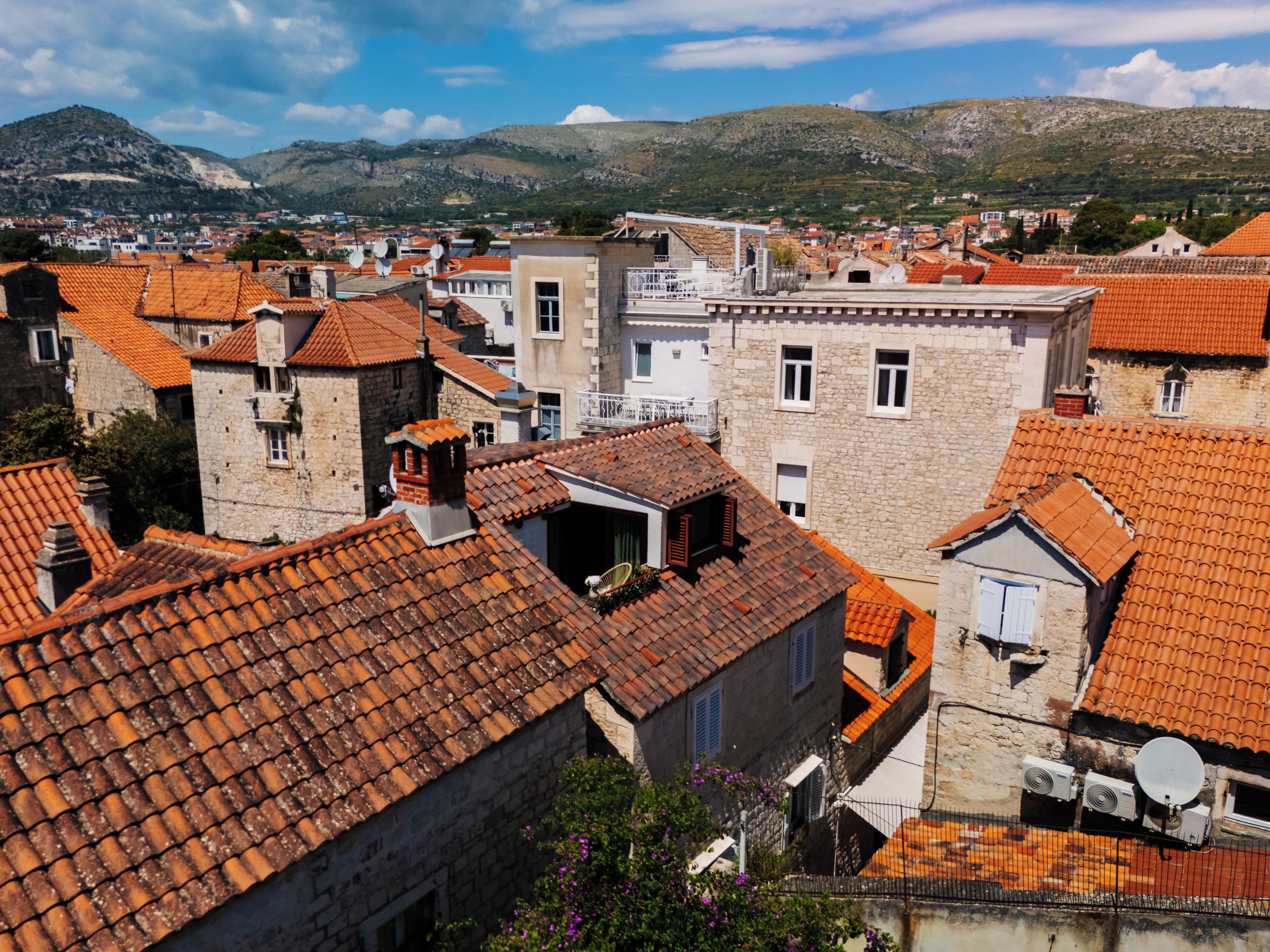 A town with red-tiled roofs and stone buildings, featuring a mix of residential and commercial structures.