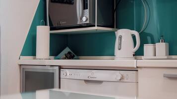 A compact kitchenette with a microwave, coffee maker, and a small refrigerator.