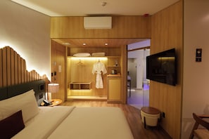 A hotel room with a bed, a bedside table, a TV, a wardrobe, and a bathroom visible through an open door. - DoubleTree by Hilton Caracol Canela (Canela)