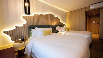 Habitación de hotel con dos camas, cabecero de madera, una mesita redonda y una mesita de noche con teléfono.