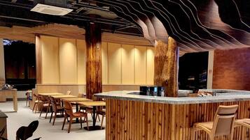 Un interior moderno con una zona de bar de madera, asientos y un diseño de techo único.