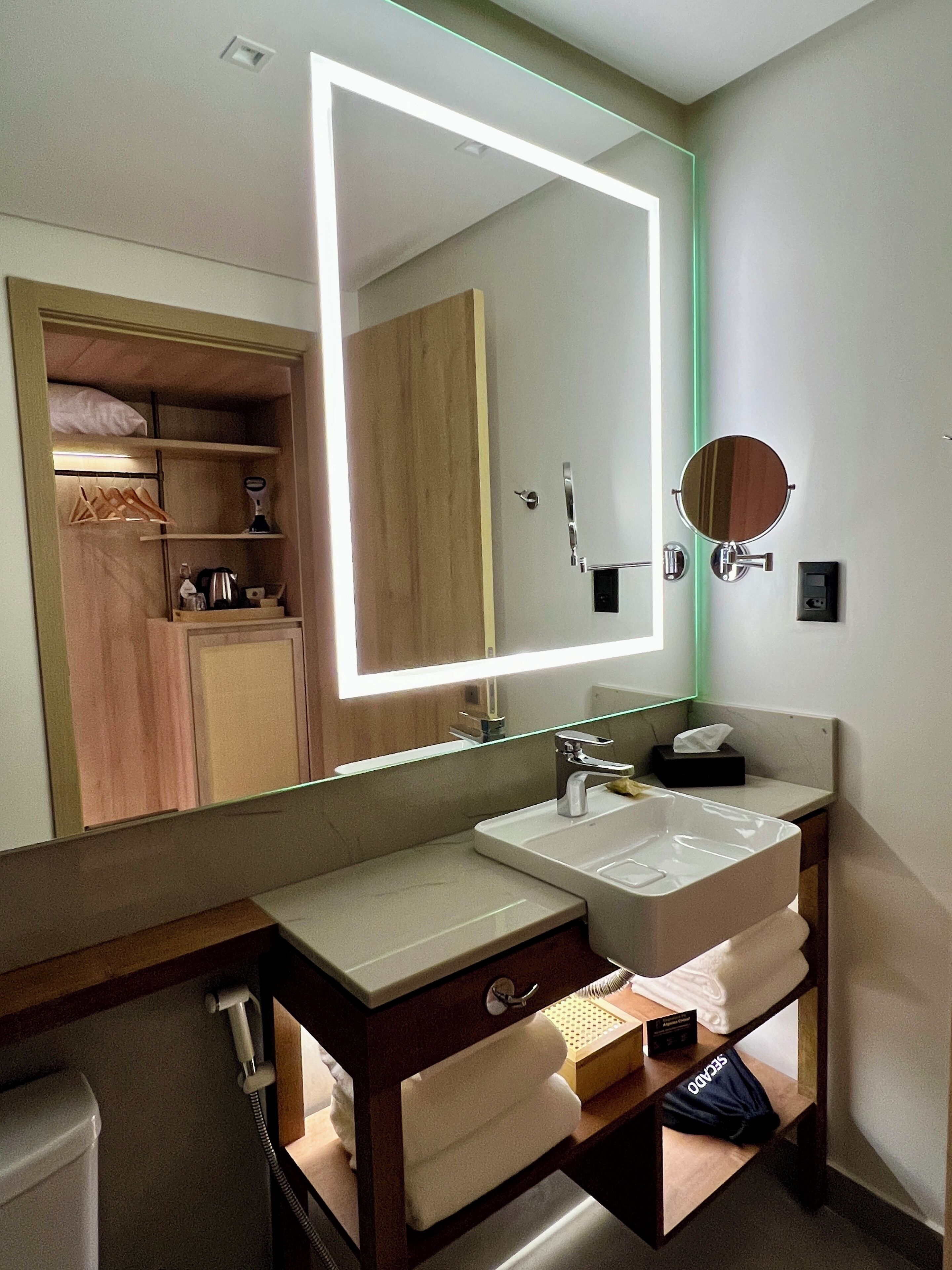 Une salle de bain moderne avec un grand miroir, un lavabo et un meuble-lavabo.