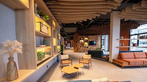 A modern interior with a sofa, chairs, and a coffee table in a lounge area. - DoubleTree by Hilton Caracol Canela (Canela)