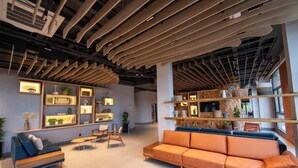 A modern interior with a wooden ceiling, built-in shelves, a sofa, and a coffee table. - DoubleTree by Hilton Caracol Canela (Canela)