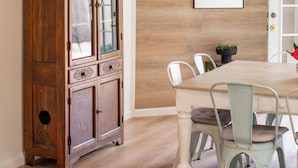 A dining area with a wooden cabinet, a white table, and light green chairs. - Parkside 4-bedroom house with complete fenced in yard in tranquil Santa Rosa. (Santa Rosa)