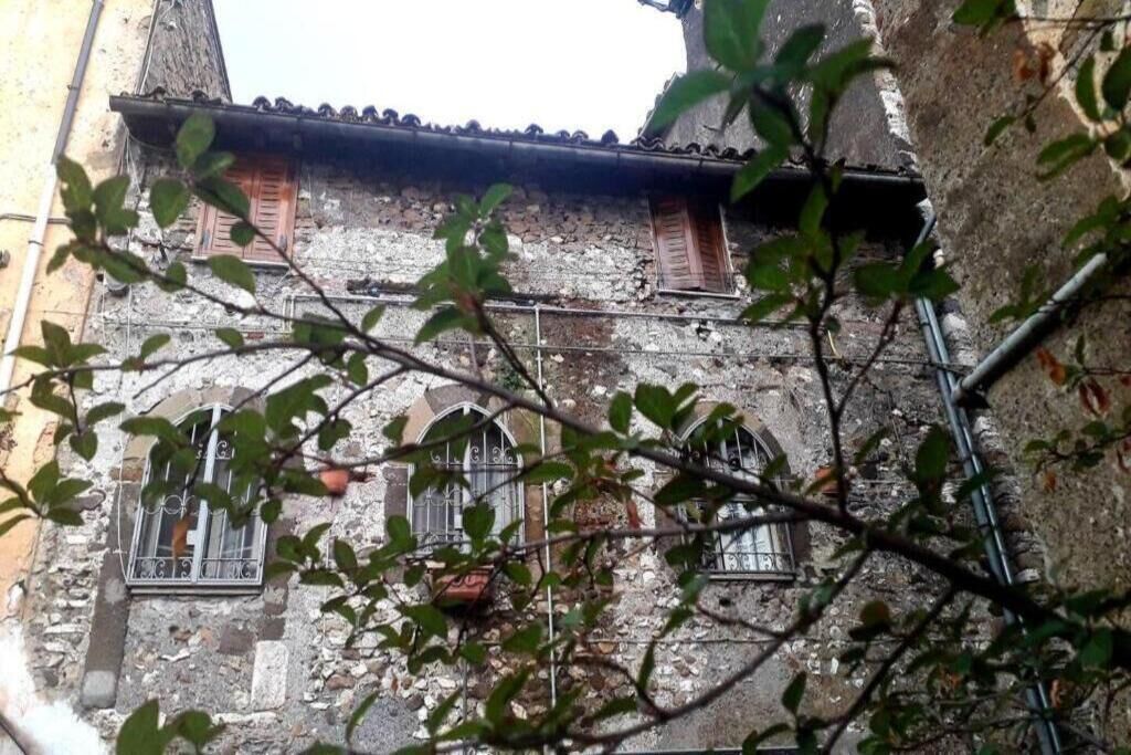 A historic building with stone walls and wooden shutters.