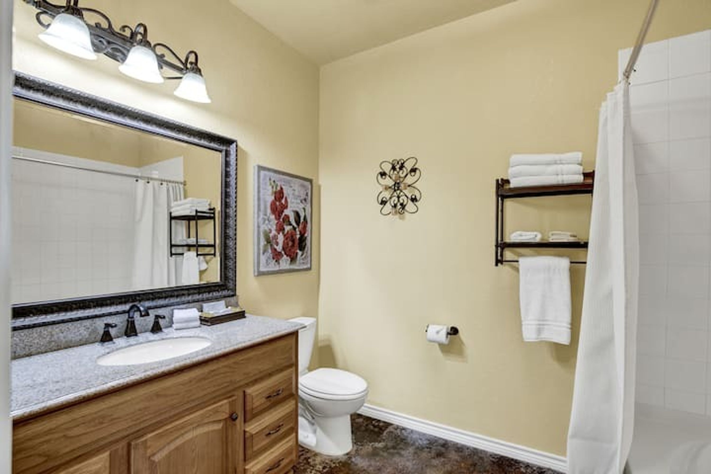 A bathroom with a sink, toilet, and shower curtain.