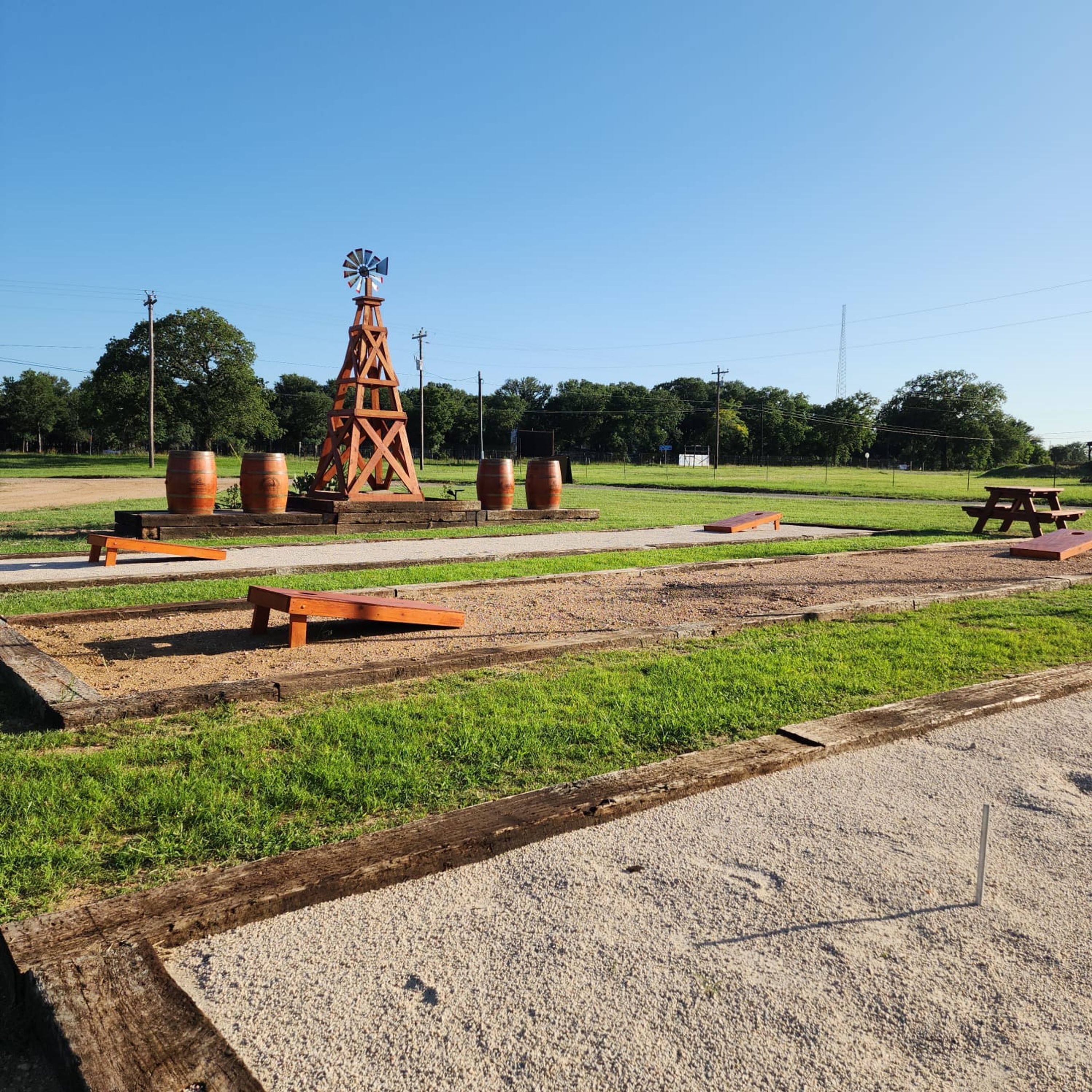 Ein Park mit Windmühle, Picknicktischen und Holzbanken.